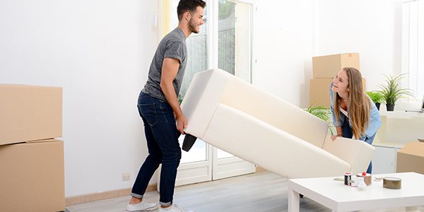 couple moving a couch in their new home